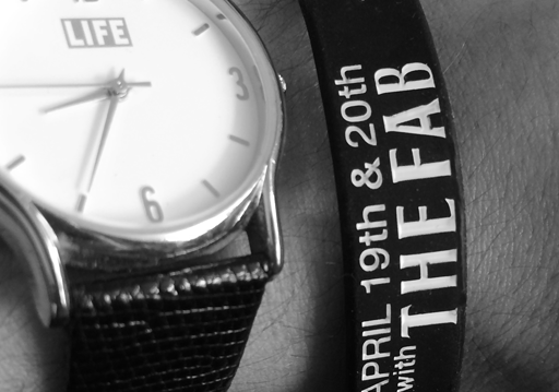 custom event wristband shown on wrist next to watch