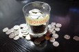 money tip cup overflowing with change and labeled donate