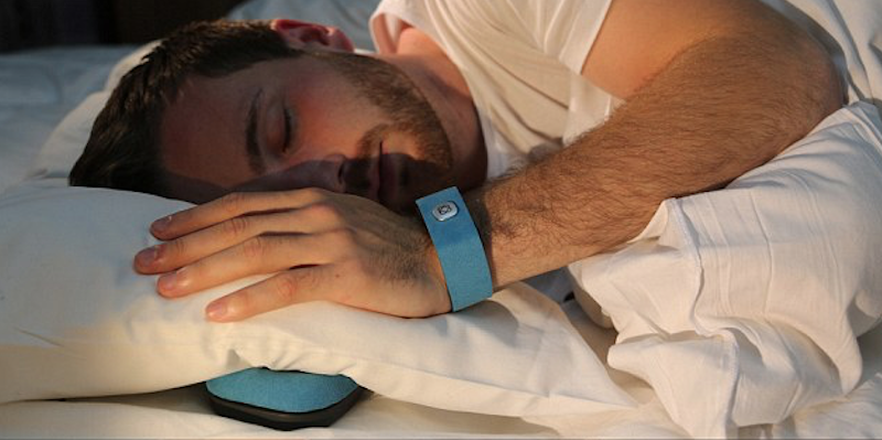 blue pillow talk wristband being worn by sleeping man
