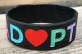 amazing adopt wristband with multicolored lettering and a heart for the O