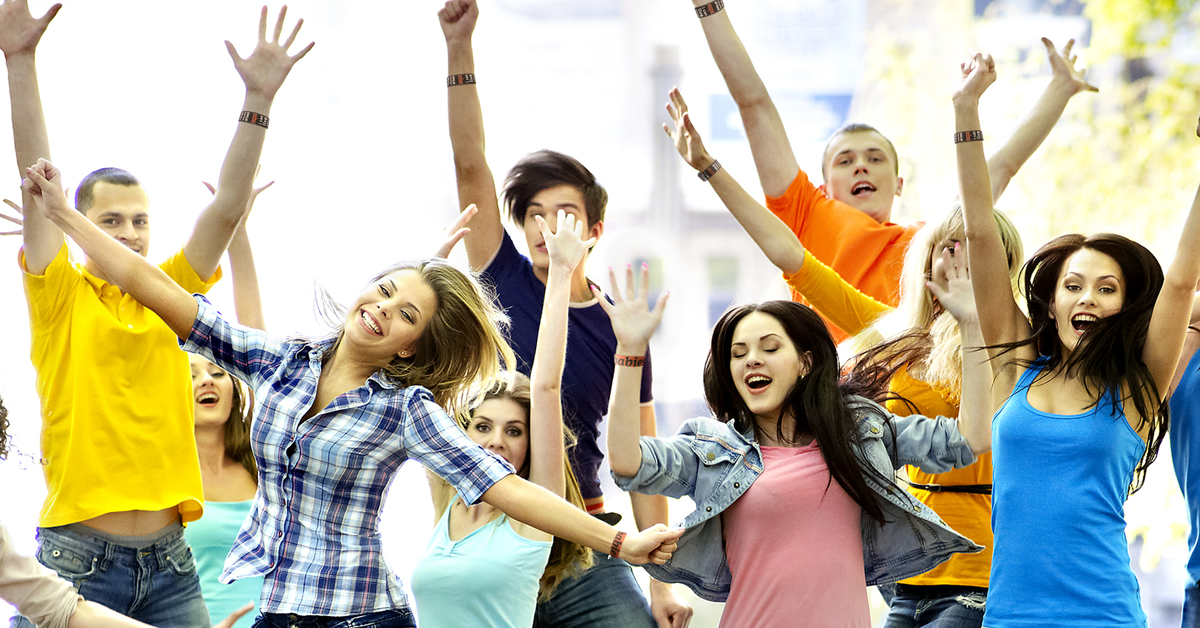a group of young adults jumping for joy over fundraising wristbands