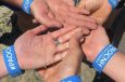 group of hands together wearing event wristbands